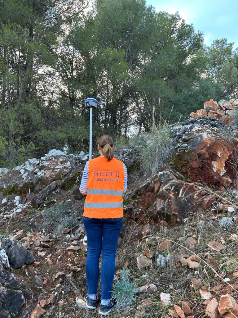 Especialista topógrafa de Geosur realizando mediciones con equipo GPS en Málaga